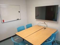 Table and chairs with monitor and whiteboard