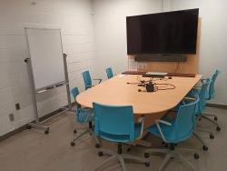 Table and chairs with monitor and whiteboard