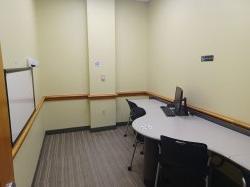 Study room with table, chairs, computer, and whiteboard