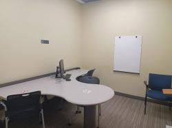 Study room with table, chairs, computer, and whiteboard